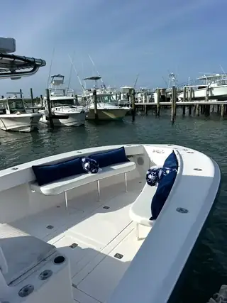 Navy-cushioned bench seats wrapping around the bow of Tom Cat