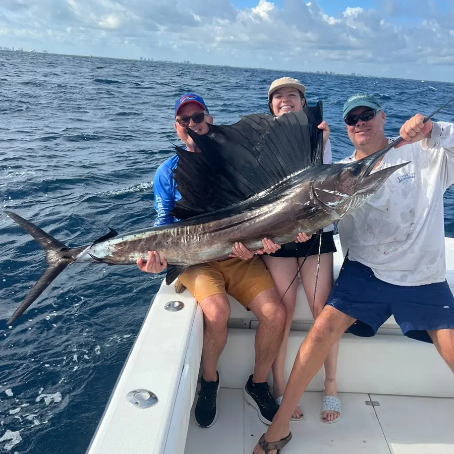Three anglers holding a sailfish caught offshore of Jupiter